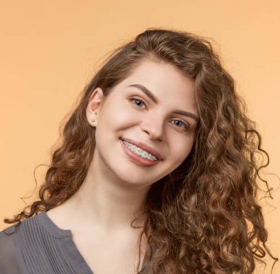 curly hair woman with brackets on biege background
