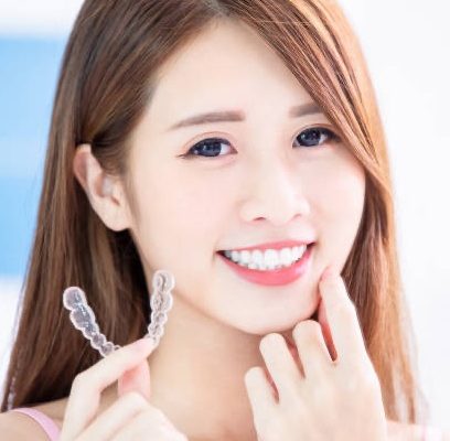 Beauty asian girl hold invisible braces with beautiful teeth