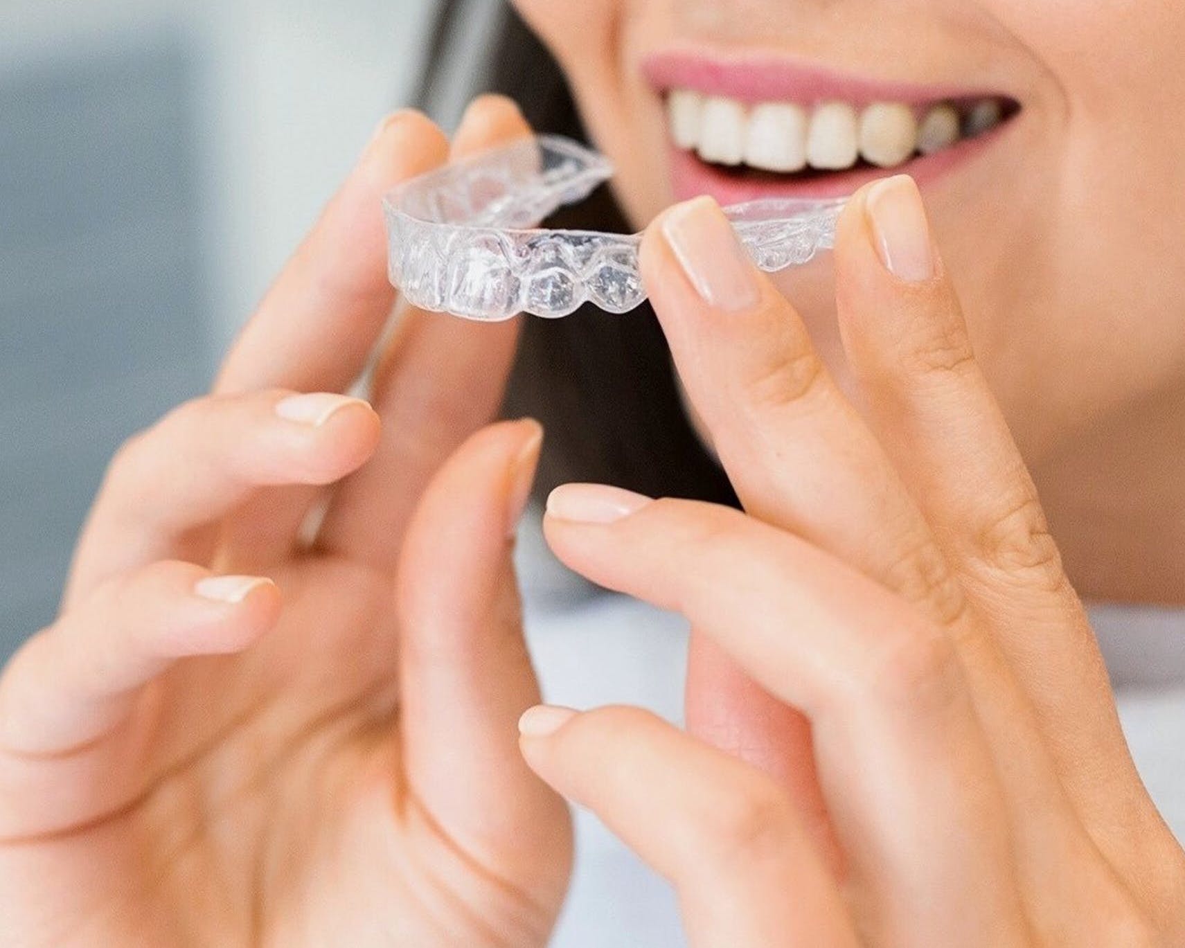 woman holding invisalign