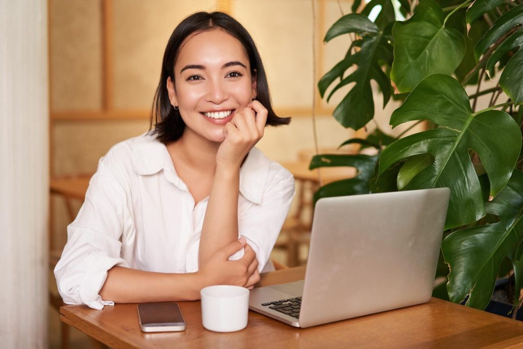 Working woman with straight teeth smiling with laptop 