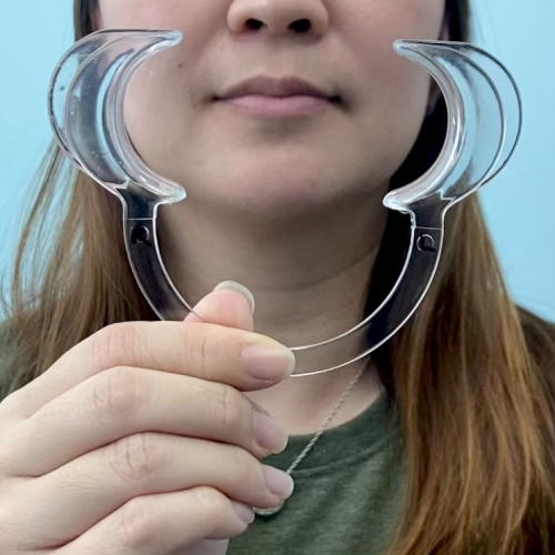 woman holding a cheek retractor