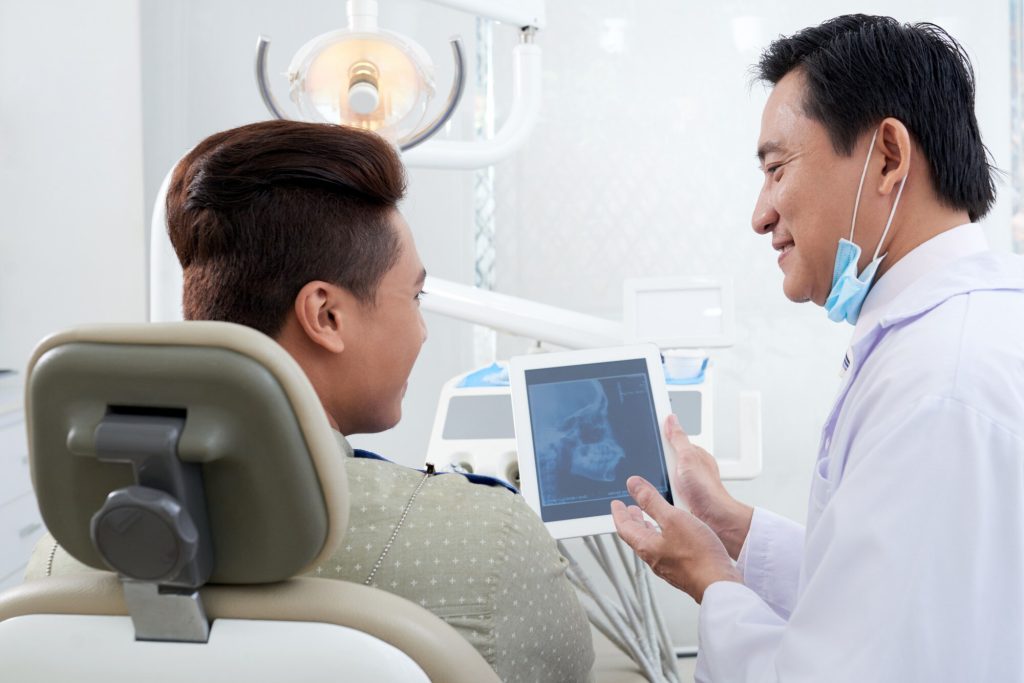 A dentist showing his patient his x-ray (lat ceph)