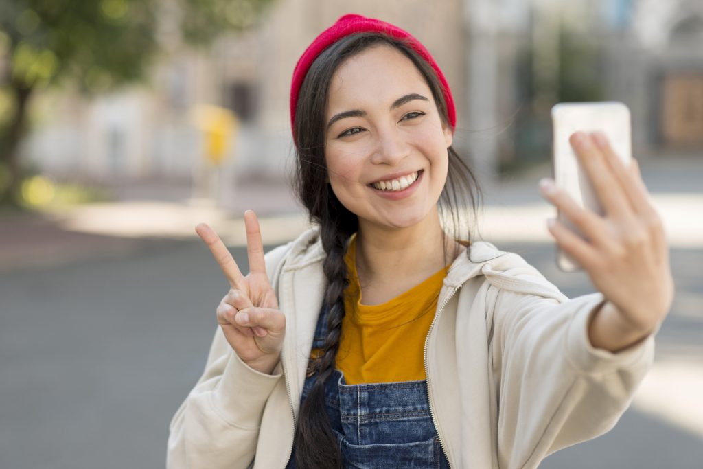 young woman taking selfie using phone
